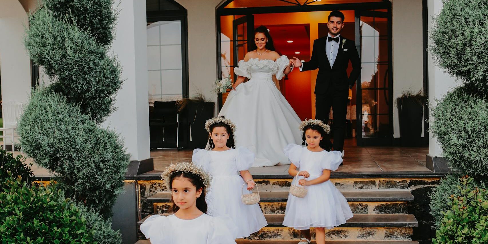 A Cute Flower Girls Walking Together with the Bride and Groom