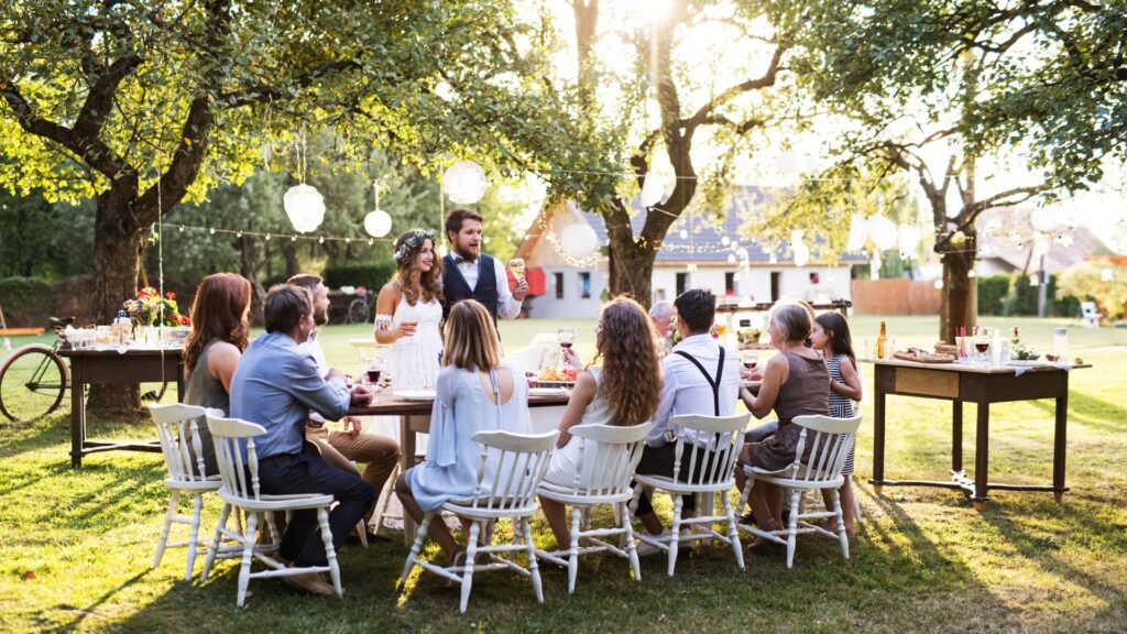 ludzie siedzą przy weselny stole w plenerze