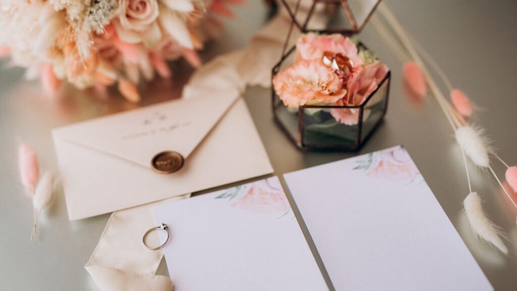 różowe zaproszenie na ślub w otoczeniu detali